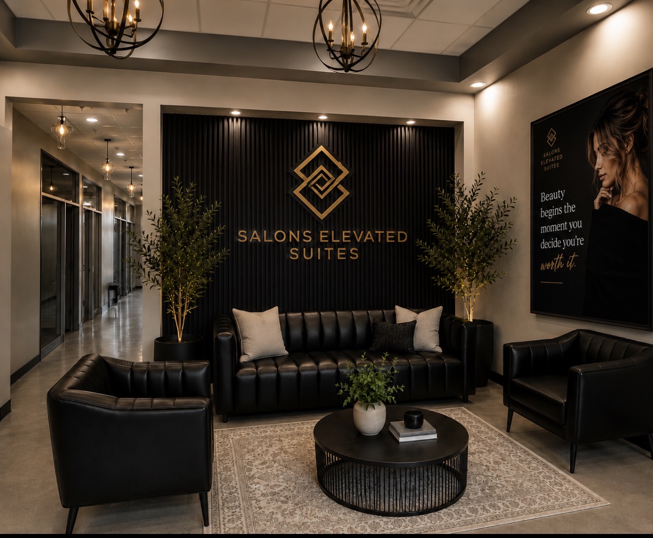 The Salons Elevated Suites lobby with black leather seating, gold logo wall and the suite hallway beyond